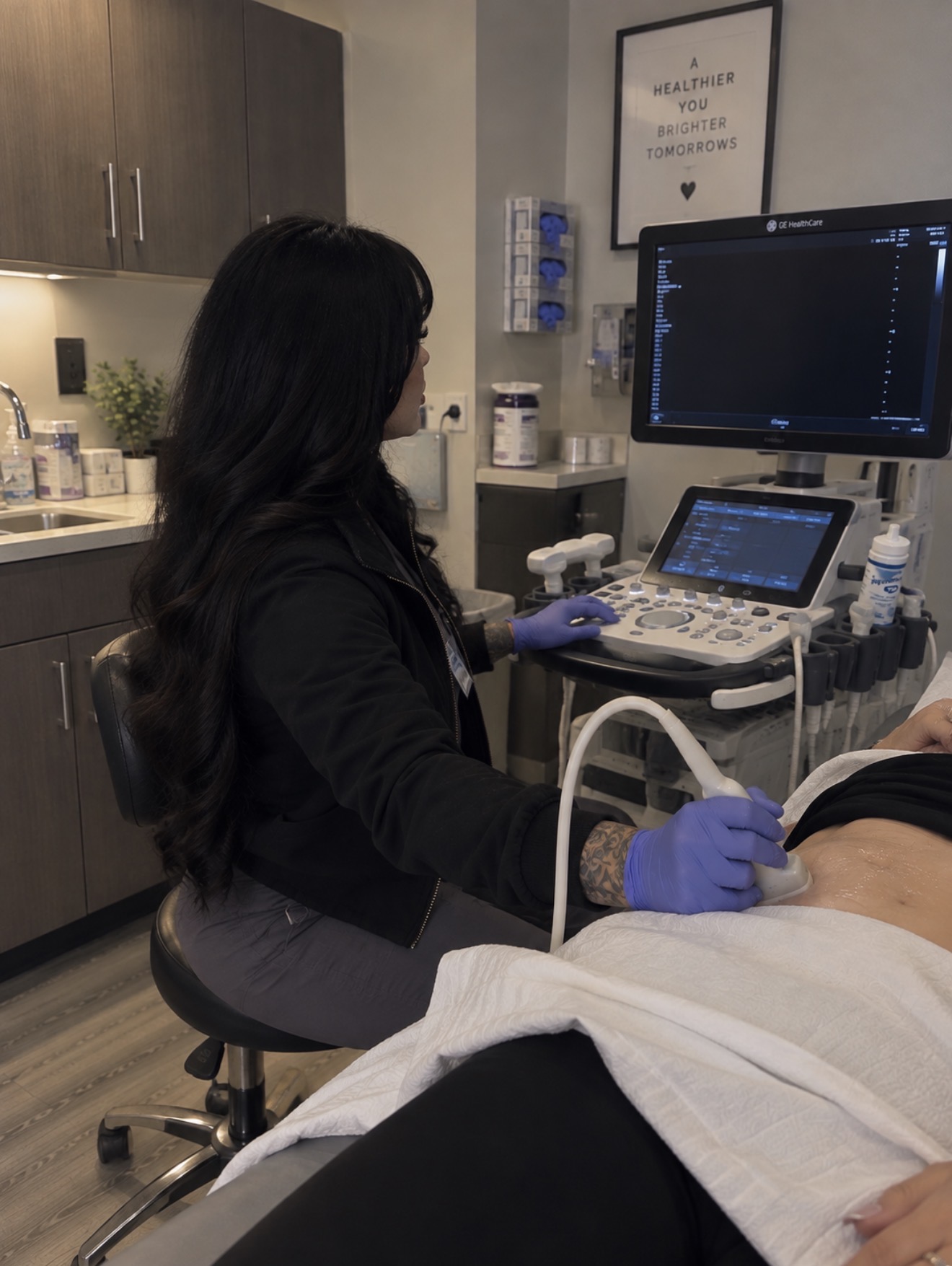 An ultrasound session with a sonographer beside the viewing screen
